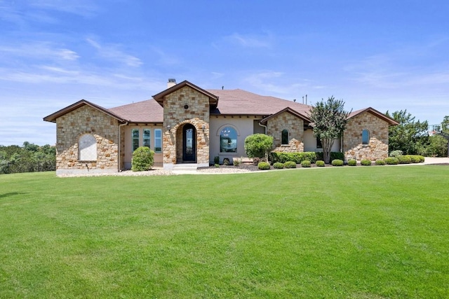 1104 Squaw Vly, Leander, TX 78641 - french country home with stone siding, a front yard, a chimney, and stucco siding