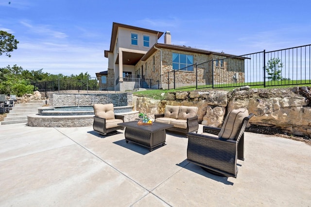 view of patio / terrace featuring fence, an outdoor living space, and an in ground hot tub