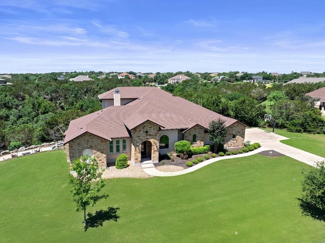 view of front of house featuring stone siding and a front lawn