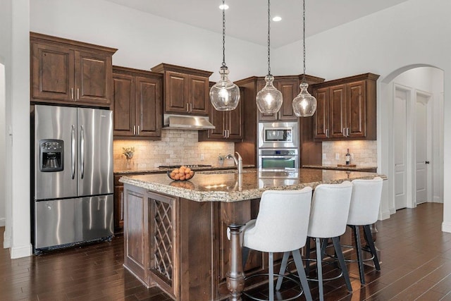 1104 Squaw Vly, Leander, TX 78641 - kitchen featuring appliances with stainless steel finishes, under cabinet range hood, dark wood-type flooring, dark brown cabinetry, and recessed lighting