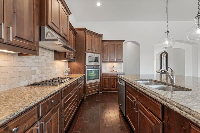 1104 Squaw Vly, Leander, TX 78641 - kitchen with stainless steel appliances, arched walkways, a sink, extractor fan, and light stone countertops