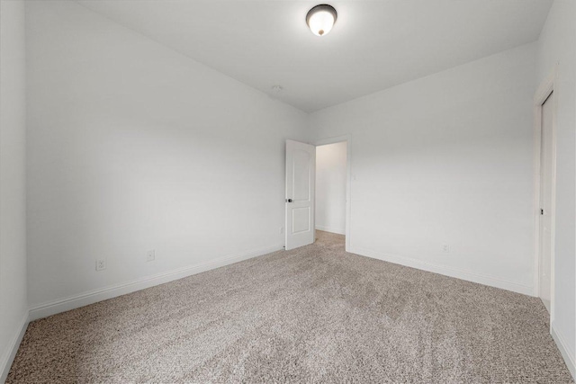 spare room with carpet and baseboards