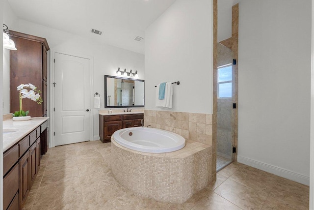 1104 Squaw Vly, Leander, TX 78641 - full bathroom with two vanities, a garden tub, a shower stall, and tile patterned flooring