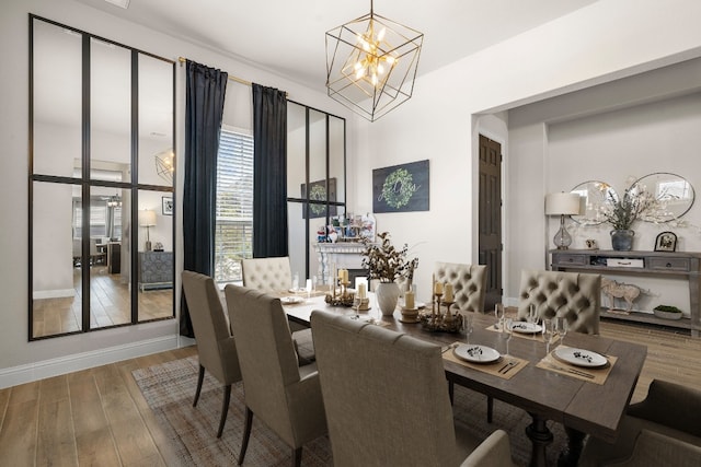 dining area with a chandelier, baseboards, and hardwood / wood-style flooring