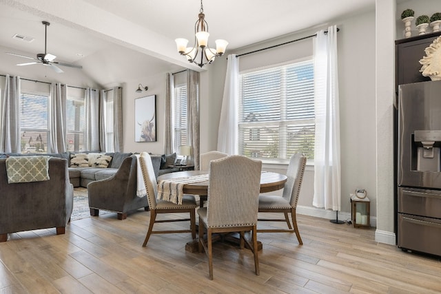 dining space with a wealth of natural light, visible vents, vaulted ceiling, and light wood-style flooring