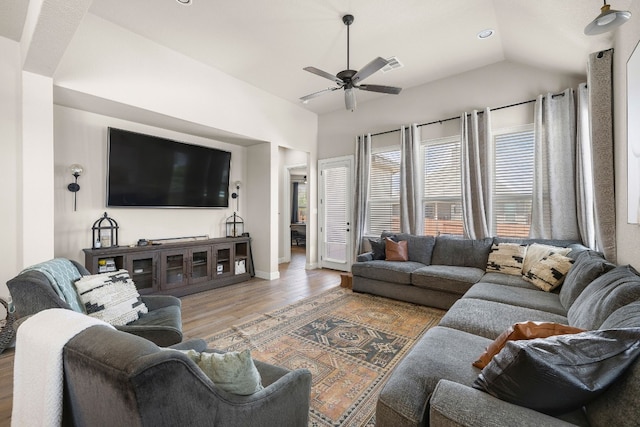 living room with wood finished floors, visible vents, baseboards, vaulted ceiling, and a ceiling fan