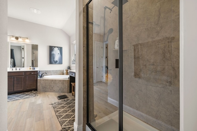 bathroom with lofted ceiling, vanity, a shower stall, and a bath