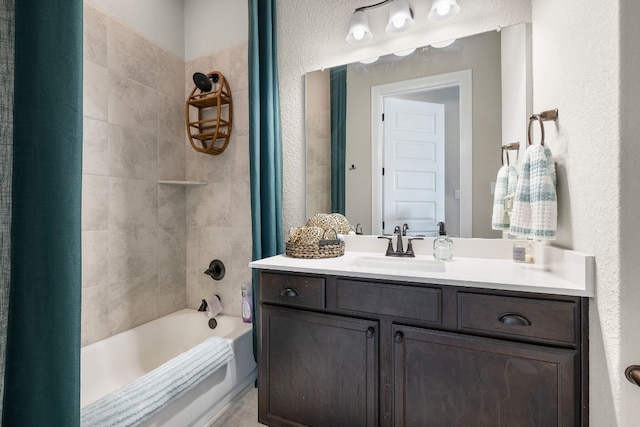 bathroom featuring bathtub / shower combination, a textured wall, and vanity