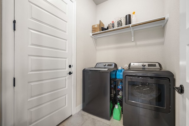 laundry area featuring laundry area, washer and clothes dryer, and light tile patterned flooring