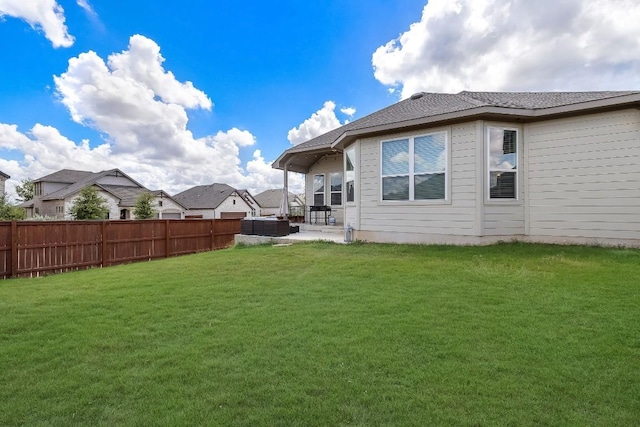 rear view of property with a patio area, a lawn, and fence