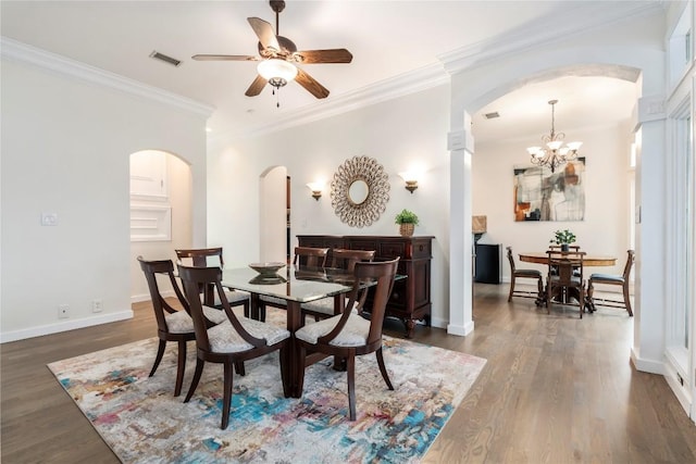 dining room featuring arched walkways, dark wood finished floors, and crown molding