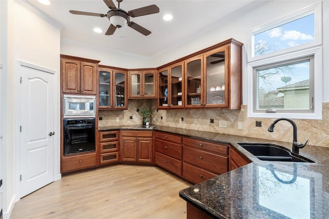 kitchen with stainless steel microwave, a sink, oven, and brown cabinets