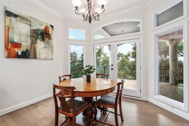 dining area with baseboards, ornamental molding, and wood finished floors