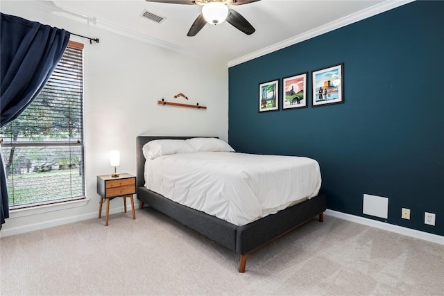 carpeted bedroom with baseboards, a ceiling fan, visible vents, and crown molding