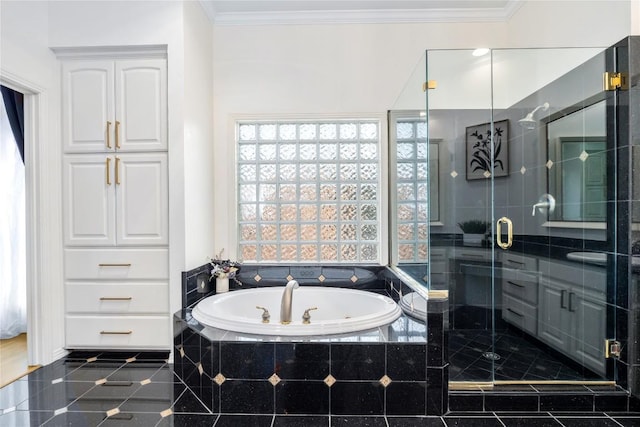 bathroom with a stall shower, a garden tub, and crown molding