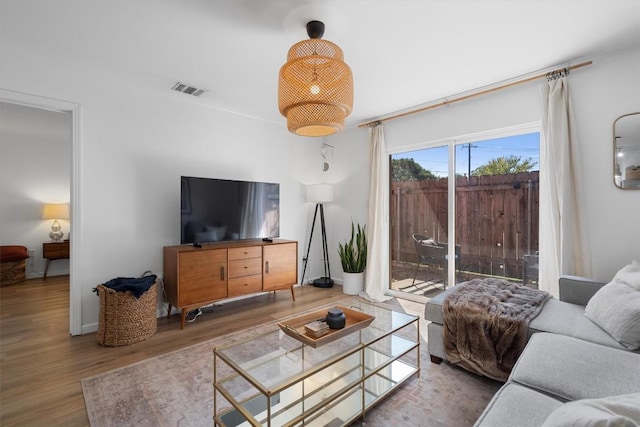 living area with visible vents and wood finished floors