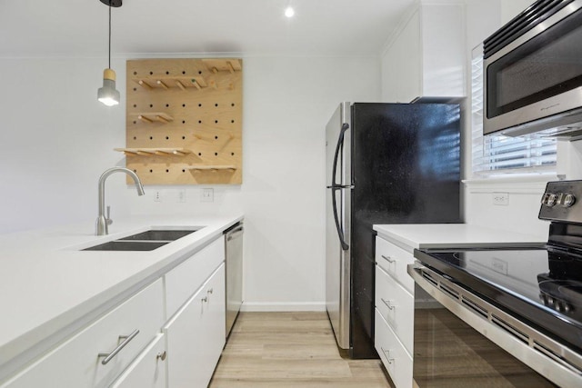 1422 Collier St Unit 102, Austin, TX 78704 - kitchen with stainless steel appliances, a sink, light countertops, white cabinets, and decorative light fixtures
