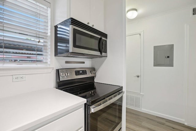 1422 Collier St Unit 102, Austin, TX 78704 - kitchen with stainless steel appliances, electric panel, white cabinets, light countertops, and light wood-type flooring