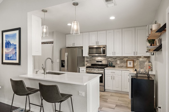 2101 Falcon Hill Dr, Austin, TX 78745 - kitchen with stainless steel appliances, open shelves, white cabinetry, backsplash, and a breakfast bar area