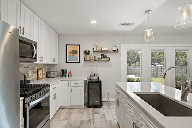 2101 Falcon Hill Dr, Austin, TX 78745 - kitchen with appliances with stainless steel finishes, healthy amount of natural light, wine cooler, white cabinetry, and recessed lighting