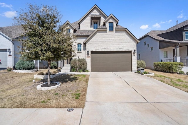 french provincial home with a garage, brick siding, driveway, and a shingled roof