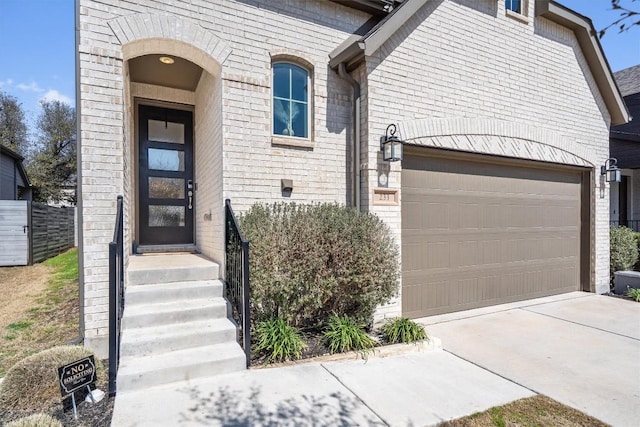 view of front of home featuring a garage, concrete driveway, and brick siding