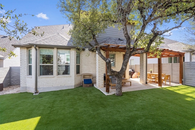 rear view of property featuring a yard, a fenced backyard, roof with shingles, and brick siding