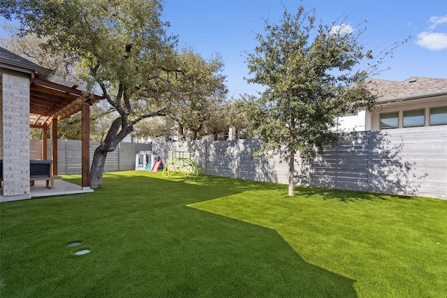 view of yard with a patio, a playground, and a fenced backyard