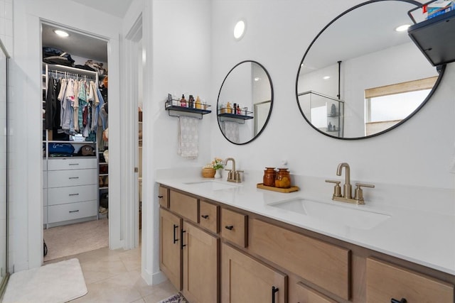 bathroom featuring a walk in closet, a sink, and a shower stall