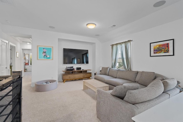 carpeted living room featuring attic access and visible vents