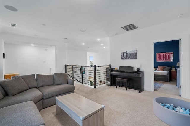 living area featuring light colored carpet, visible vents, baseboards, and recessed lighting