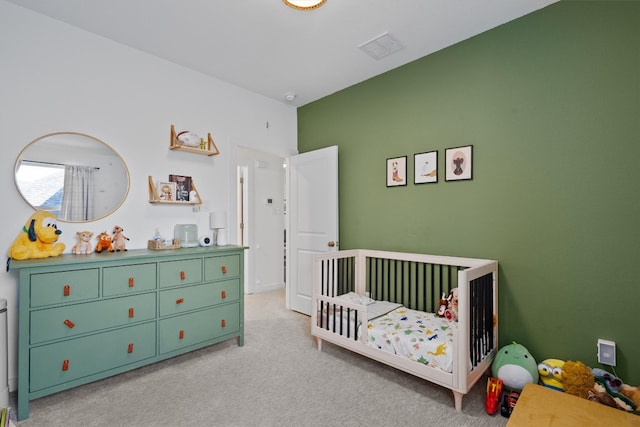 carpeted bedroom featuring a nursery area and visible vents