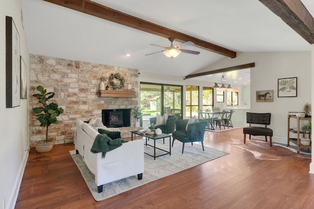 living area featuring vaulted ceiling with beams, a fireplace, wood finished floors, and baseboards