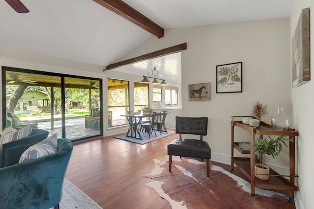 living area featuring lofted ceiling with beams, ceiling fan, wood finished floors, and a sunroom