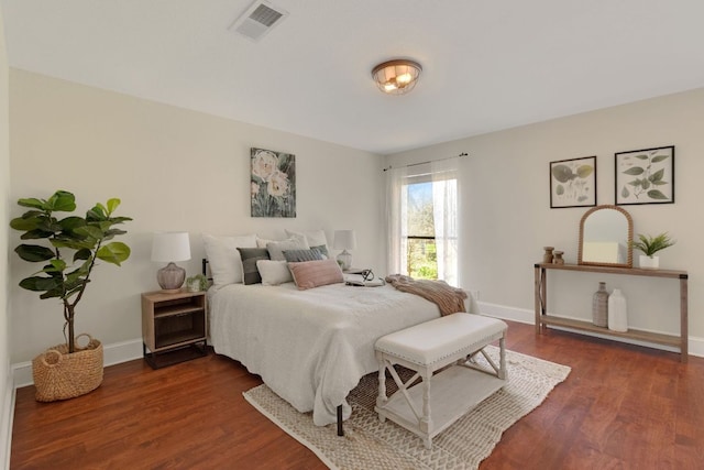 bedroom featuring visible vents, baseboards, and dark wood-type flooring