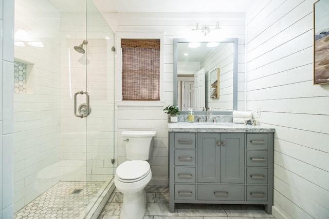 bathroom featuring marble finish floor, a stall shower, vanity, and toilet