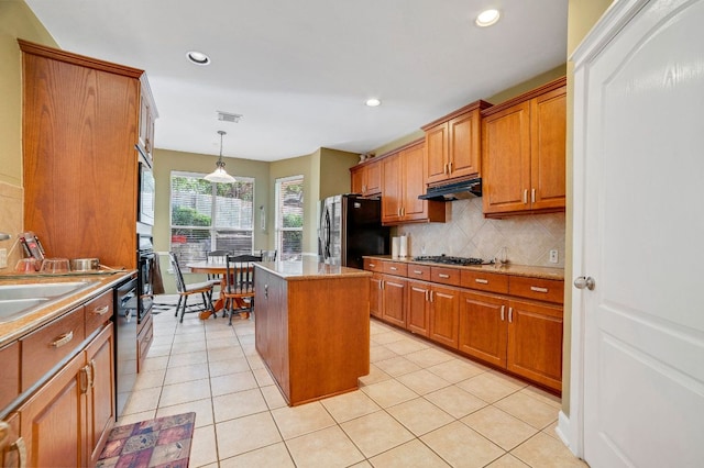 kitchen with under cabinet range hood, visible vents, appliances with stainless steel finishes, brown cabinets, and tasteful backsplash