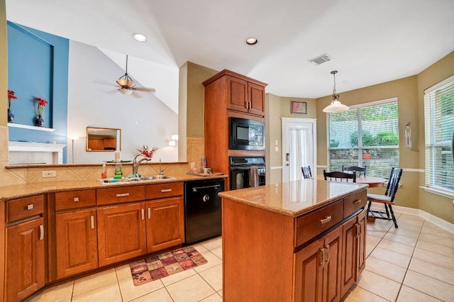 kitchen with a sink, visible vents, hanging light fixtures, light stone countertops, and black appliances