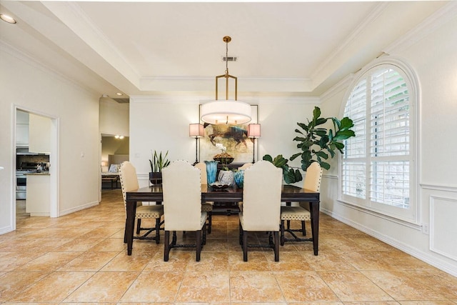 dining room featuring light tile patterned floors, visible vents, a tray ceiling, and crown molding