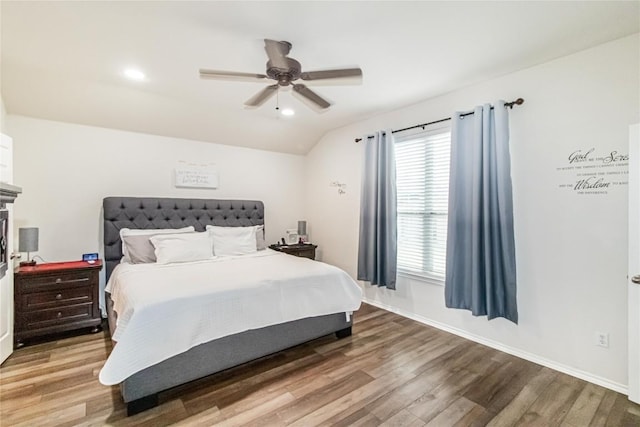 bedroom featuring a ceiling fan, lofted ceiling, baseboards, and wood finished floors