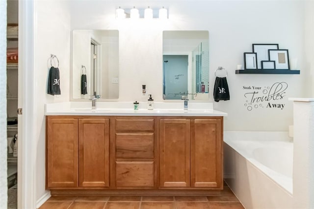 bathroom with a sink, a bath, and tile patterned floors