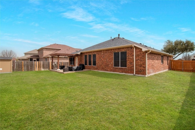 rear view of property featuring brick siding, a patio, a lawn, a pergola, and a fenced backyard