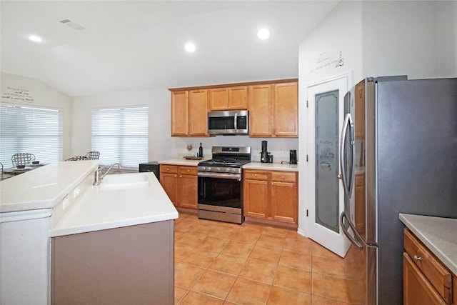 kitchen with light tile patterned floors, lofted ceiling, appliances with stainless steel finishes, a sink, and recessed lighting