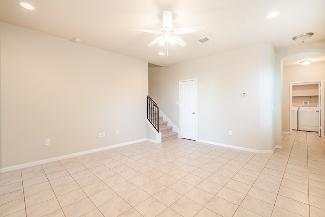 empty room featuring visible vents, separate washer and dryer, arched walkways, ceiling fan, and stairs