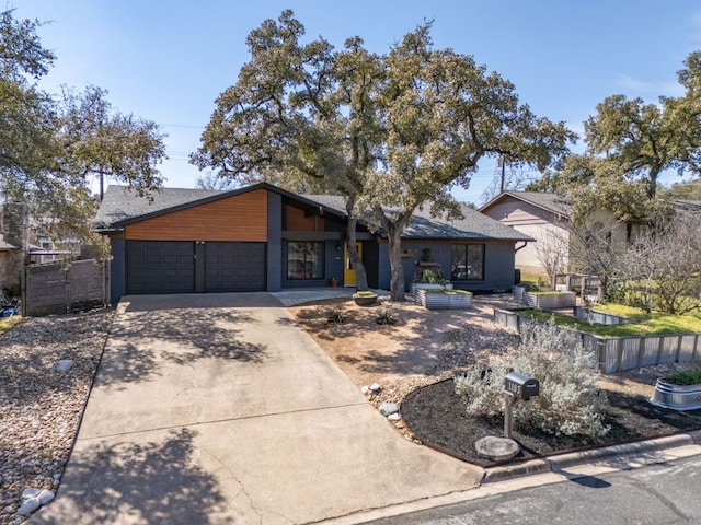 view of front of home with concrete driveway, fence, and an attached garage