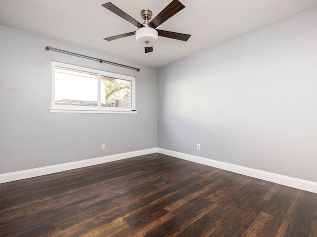 empty room featuring a ceiling fan, dark wood finished floors, and baseboards