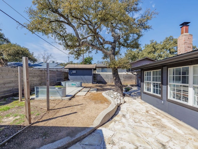 view of yard featuring an outbuilding, a shed, a fenced backyard, and a garden