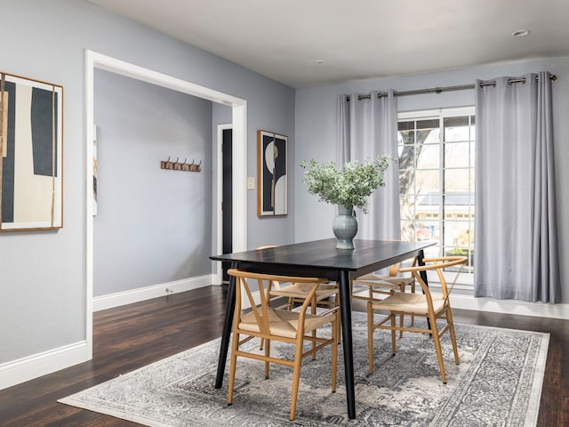 dining space featuring baseboards and wood finished floors