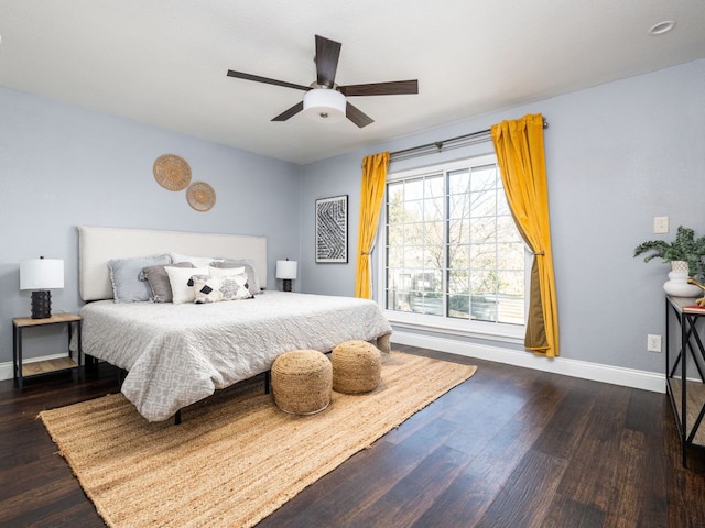 bedroom with ceiling fan, wood finished floors, and baseboards