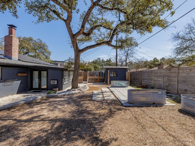 view of yard featuring a patio, french doors, and a fenced backyard